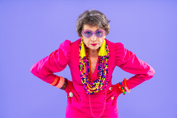 Happy and funny senior old woman wearing fashinable clothing on colorful background- Modern cool...