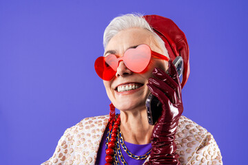 Happy and funny senior old woman wearing fashinable clothing on colorful background- Modern cool fancy grandmother portrait, concepts about elderly and older people - obrazy, fototapety, plakaty