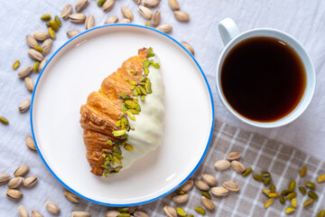 croissant with cream and pistachios served with tea