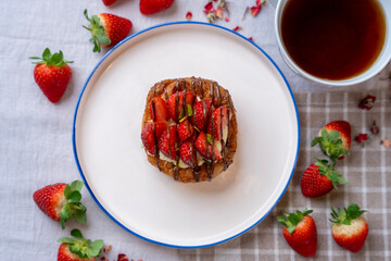 Strawberry and chocolate croissant, cup of tea and fresh strawberries. top view