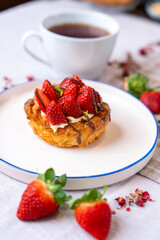 Strawberry and chocolate croissant, cup of tea and fresh strawberries. top view