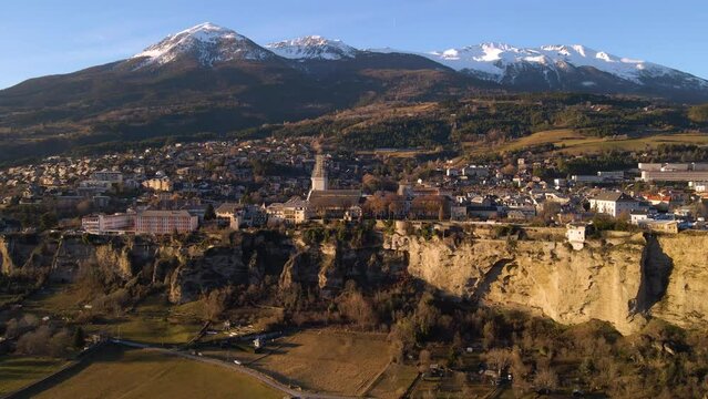 Winter aerial view of Embrun and its famous cliff-top plateau in Durance Valley in Hautes-Alpes. French Alps, France