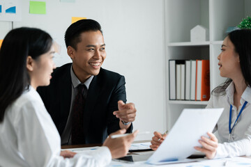 Fototapeta premium Smiling diverse employees colleagues have fun laugh cooperate brainstorm at office team meeting. Happy multiethnic businesspeople work together