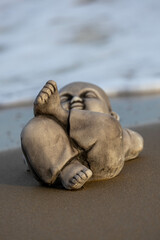 Fototapeta na wymiar Little buddha statue on the beach