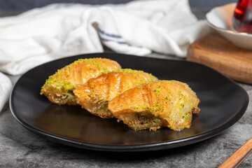 Pistachio baklava. Sobiyet baklava with pistachios on a dark background. Turkish cuisine flavors. Close up