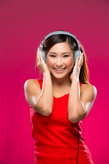 Happy Asian Woman listening to music on headphones.