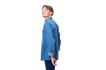 portrait of a young stylish european guy with golden hair dressed in a blue denim shirt on a...