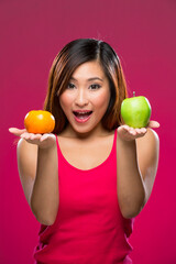 Happy Chinese Woman holding fruit on colorful background.