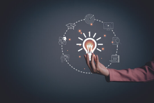 Woman hand holding light bulb with online education training. Concept of digital courses to develop new skills, e-learning on internet for personal development, learning, graduation, certificate.