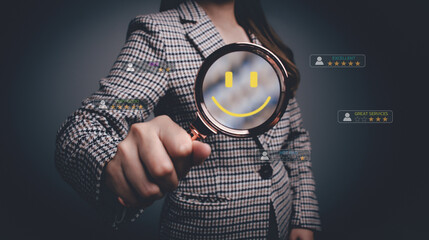 Woman using magnifying glass focus to virtual smile face icon. popup five stars icon for feedback...