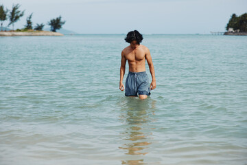 Swimming Man enjoying a Tropical Beach Vacation: Freedom in the Ocean Splash