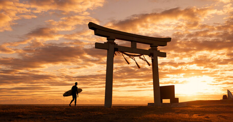 Torii gate, sunset and man with surfboard, ocean and travel adventure in Japan with orange sky. Shinto architecture, Asian culture and calm beach in Japanese nature with person at spiritual monument.