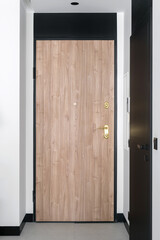 Closed wooden door with metal handle, lock and keyhole