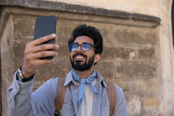 Smiling young man making pictures on a telephone