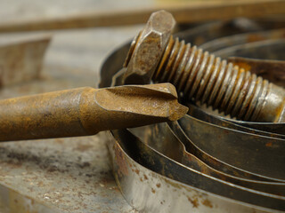 Old tools and a roll of galvanized metal tape lie on a sheet of metal with traces of rust, background