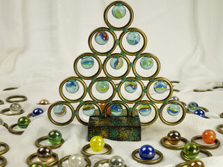 Handmade Christmas tree made of brass rings and glass balls against the white background, holiday concept.
