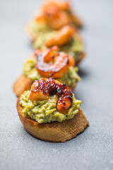 Appetizer canape with shrimp on cutting board on table close up