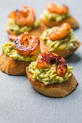 Appetizer canape with shrimp on cutting board on table close up