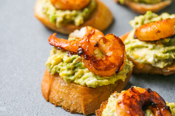 Appetizer canape with shrimp on cutting board on table close up