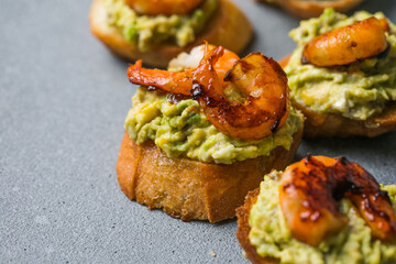 Appetizer canape with shrimp on cutting board on table close up