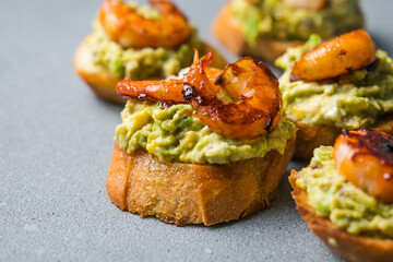 Appetizer canape with shrimp on cutting board on table close up
