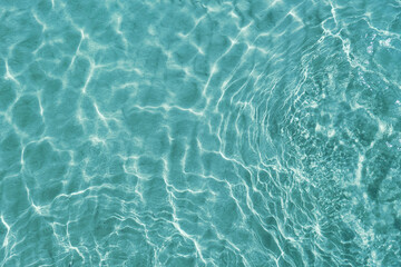 Blue water surface viewed from above in outdoor sea, sun reflection, dimply. Surface Abstract Background. Clear water in sea with ripple in clean aqua liquid. Summer wallpaper blue background - obrazy, fototapety, plakaty