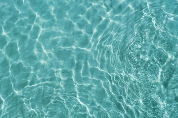 Fotobehang Blue water surface viewed from above in outdoor sea, sun reflection, dimply. Surface Abstract Background. Clear water in sea with ripple in clean aqua liquid. Summer wallpaper blue background © SandyHappy