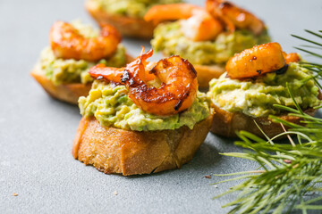 Appetizer canape with shrimp on cutting board on table close up