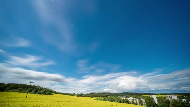 time lapse of clouds on a summer rapeseed flowering field