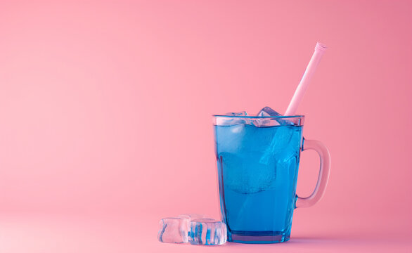 Cup with blue drink, pink background. Minimal style.