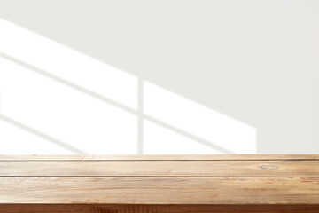 table with window shadow against white wall for product mockup display