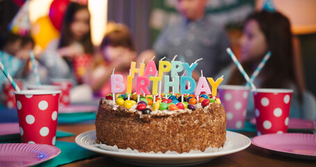 Celebration birthday cake with colorful sprinkles and candles with Happy Birthday words while...