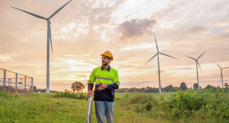 Engineer wearing uniform inspection and survey work in wind turbine farms rotation to generate...