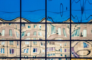 crooked reflection of houses in a glass window