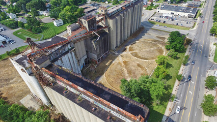 Aerial View of Abandoned Grain Silos and Suburban Contrast