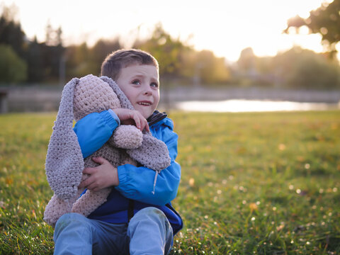 Little boy child portrait in autumn park with soft toy