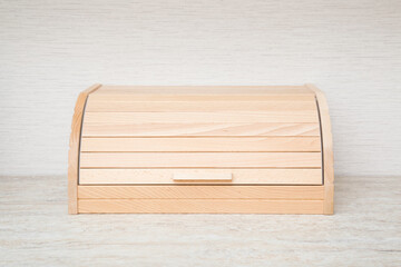 New wooden bread box on table top at home kitchen. Closeup. Front view.