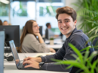 Young student smiles facing the camera and opens laptop to do assignments