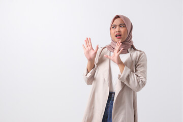 Portrait of attractive Asian hijab woman in casual suit forming a hand gesture to avoid something....