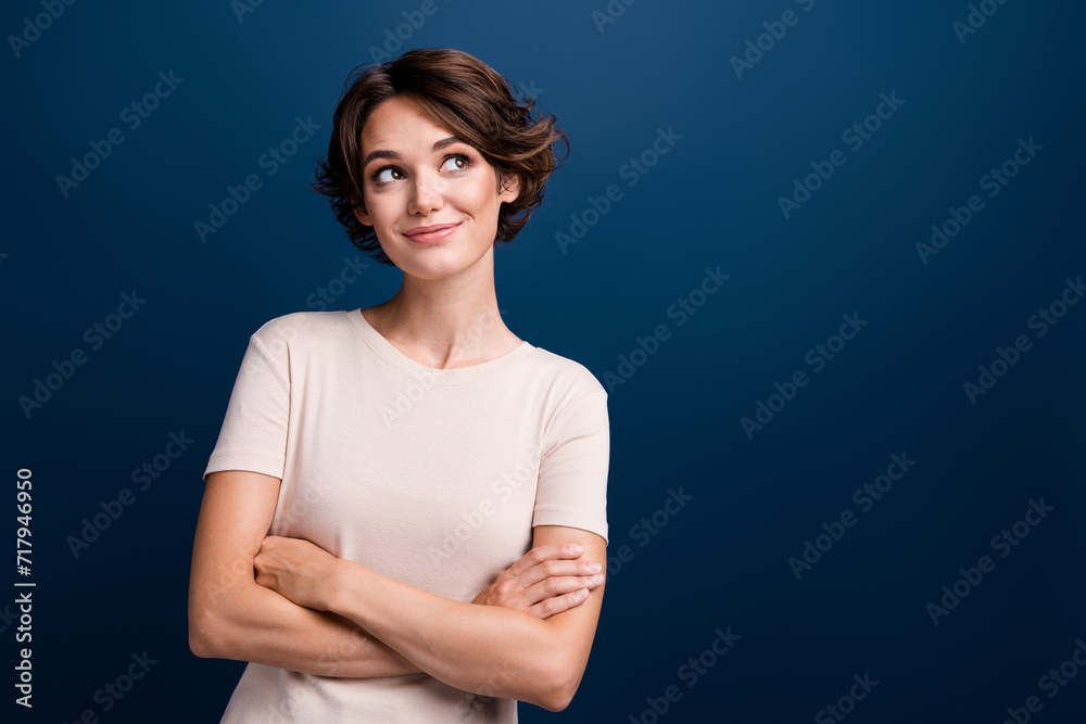 Poster Portrait of interested young girl manager hold arms folded look empty space wonder isolated on dark blue color background