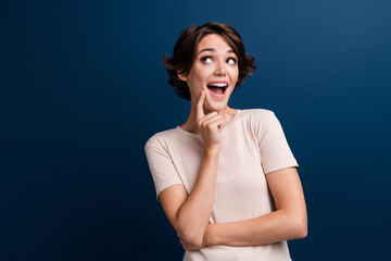 Portrait of pretty interested girl holding finger on chin have idea look side amazed shocked...