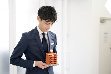 マンションの不動産をお勧めするビジネスマン