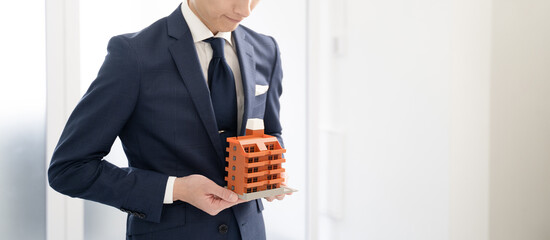 マンションの不動産をお勧めするビジネスマン