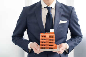 マンションの不動産をお勧めするビジネスマン