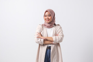 Portrait of young successful Asian hijab woman in casual suit looking at camera, holding hands crossed folded. Isolated image on white background