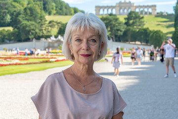 Portrait of an elderly woman on the background of a city park.