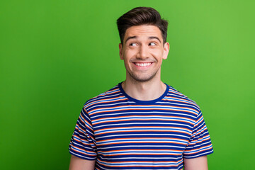 Portrait of positive creative minded person beaming smile look interested empty space isolated on green color background