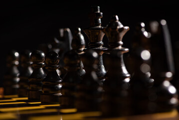 Chess pieces,beautiful old chess pieces on a board, black background, selective focus.