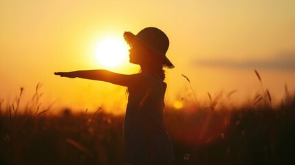 Fototapeta premium Silhouette of dreaming little girl in hat pulls hand to warm sun Religion helping hand Preteen child enjoy beautiful summer nature during amazing sunset or sunrise Prayer in religion concept