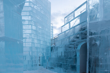 Detail of the interior of the ice palace in construction for the annual winter festival seen at sunrise, with old town building in the background, Quebec City, Quebec, Canada